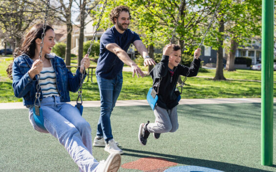 Young family enjoys a sunny day at a public playground in Kansas