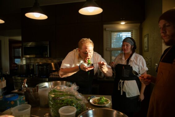 With the sun beaming on his face, a chef takes a bite of a fresh meal in the kitchen before its brought our for service